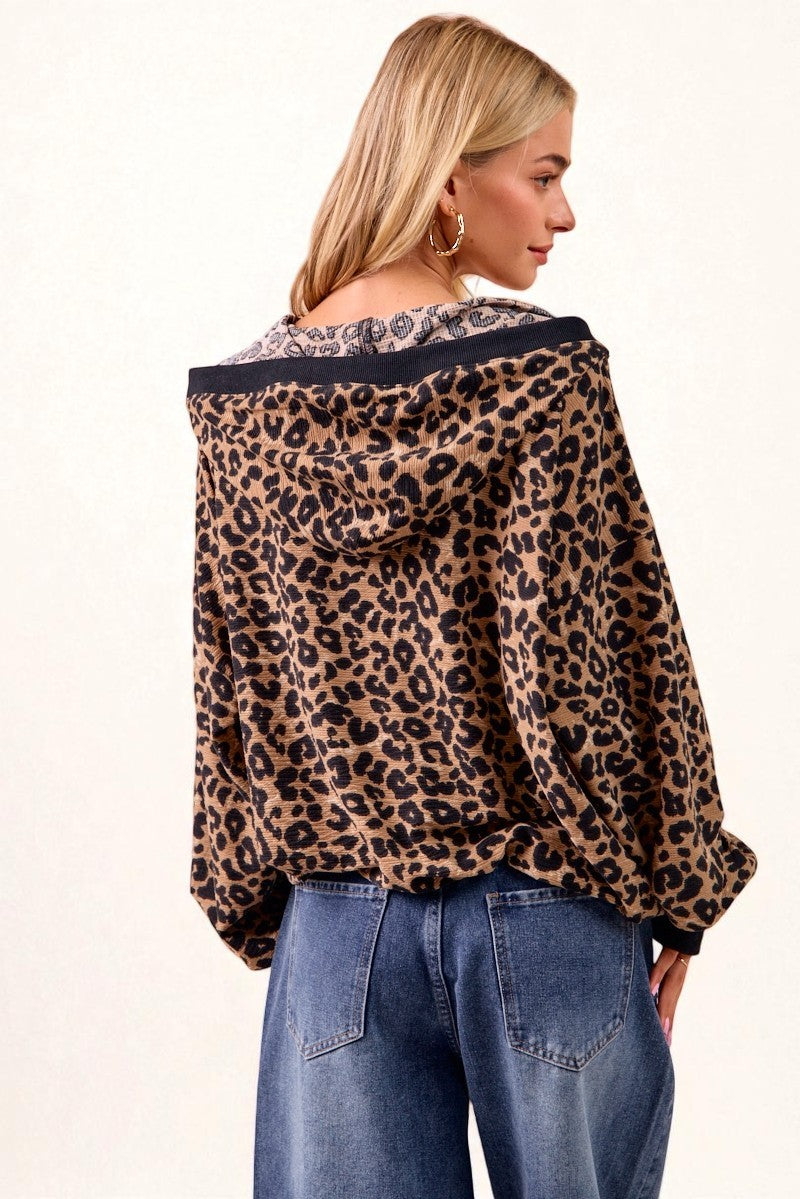 Woman wearing a leopard print jacket and blue jeans on a white background