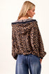 Woman wearing a leopard print jacket and blue jeans on a white background