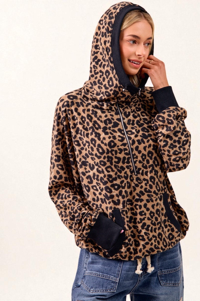 Person wearing a leopard print hoodie with a plain background
