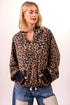 Woman wearing a leopard print jacket and blue jeans on a white background