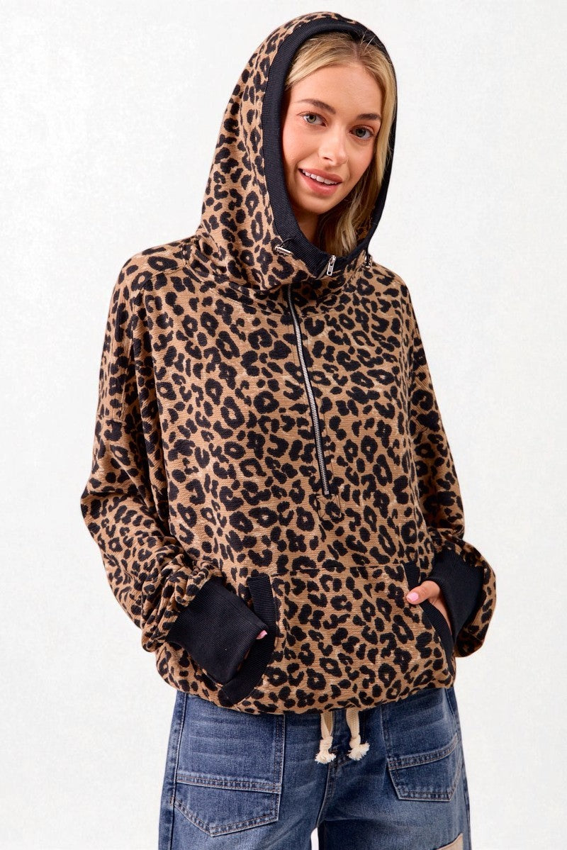 Person wearing a leopard print hoodie with a plain background