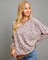 Woman wearing a leopard print blouse against a gray background