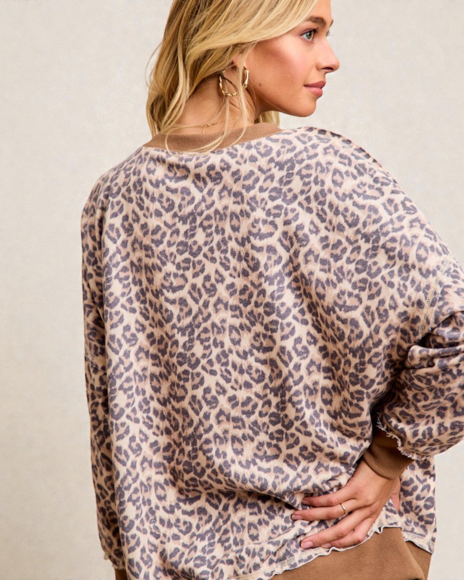 Woman wearing a leopard print top against a plain background