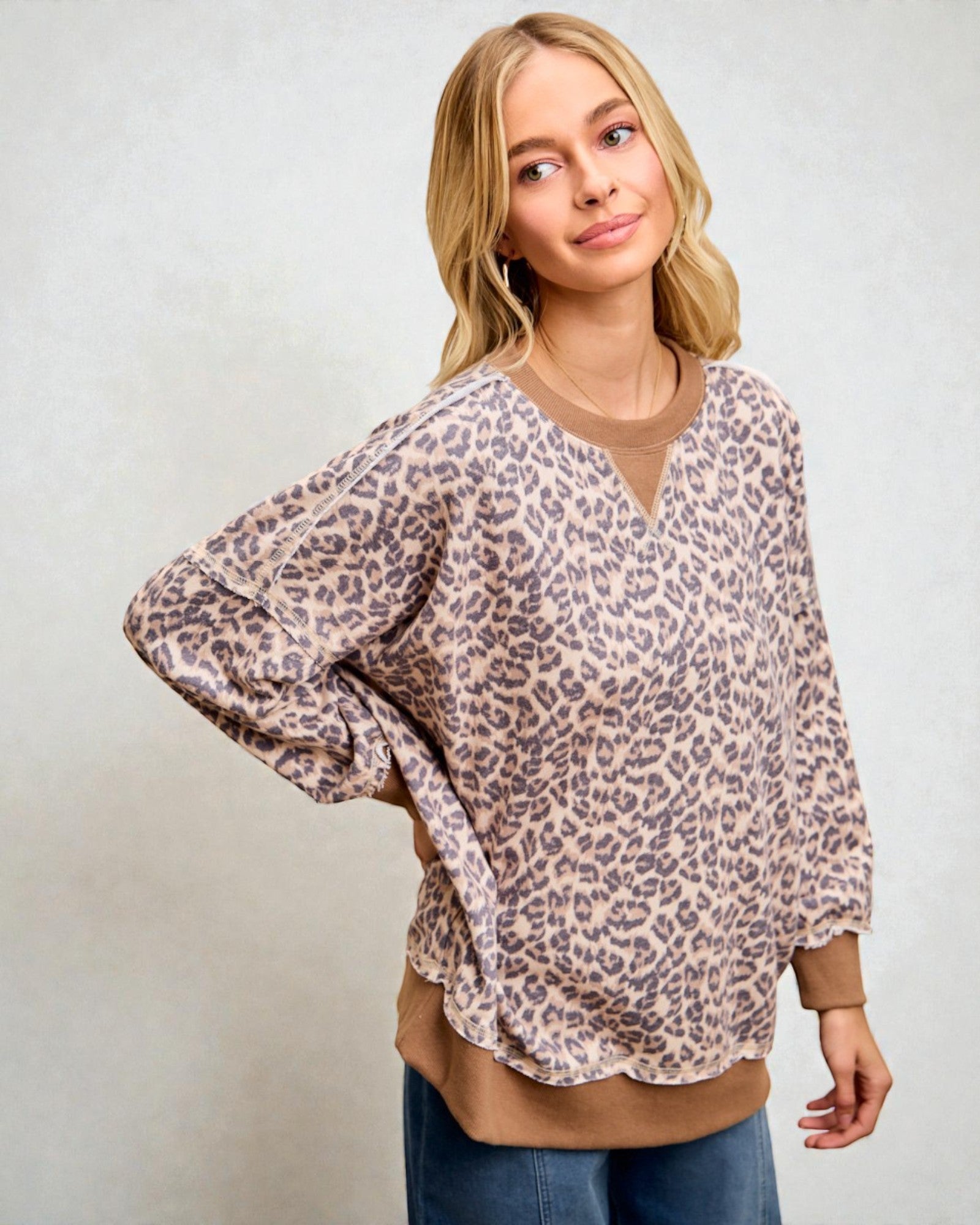Woman wearing a leopard print blouse with a plain background