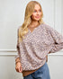 Woman wearing a leopard print blouse against a white background