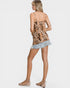 Woman wearing a leopard print top and denim shorts on a white background