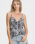 Woman wearing a leopard print camisole top on a plain background