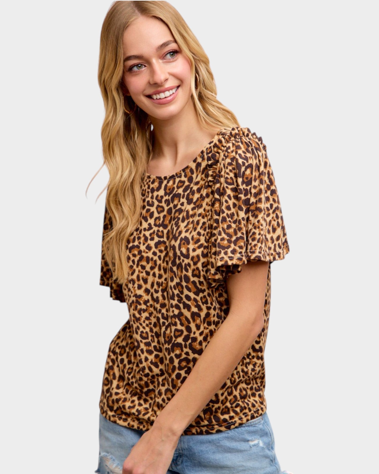 Woman wearing a leopard print top on a plain background