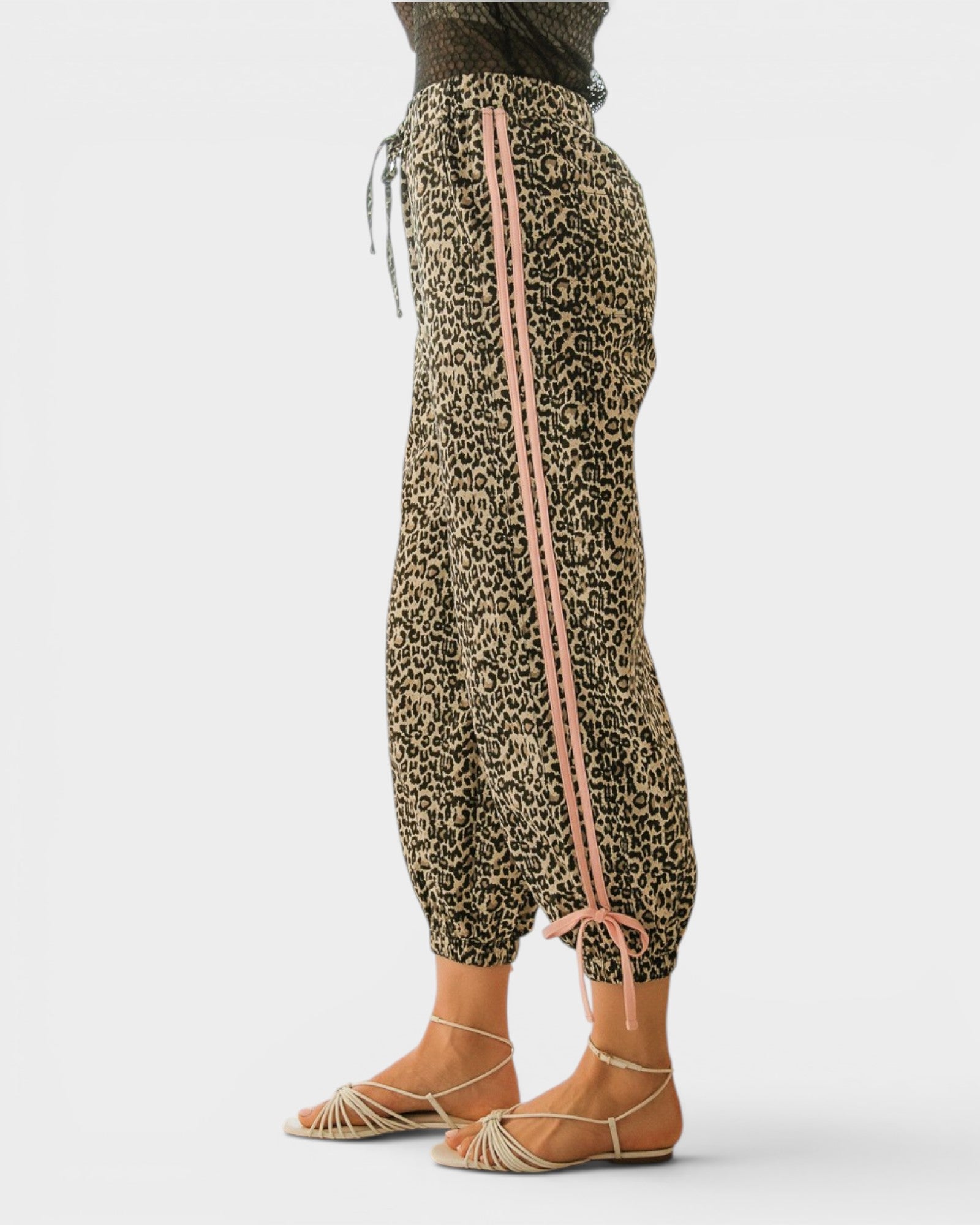 Leopard print pants with pink drawstrings on a white background