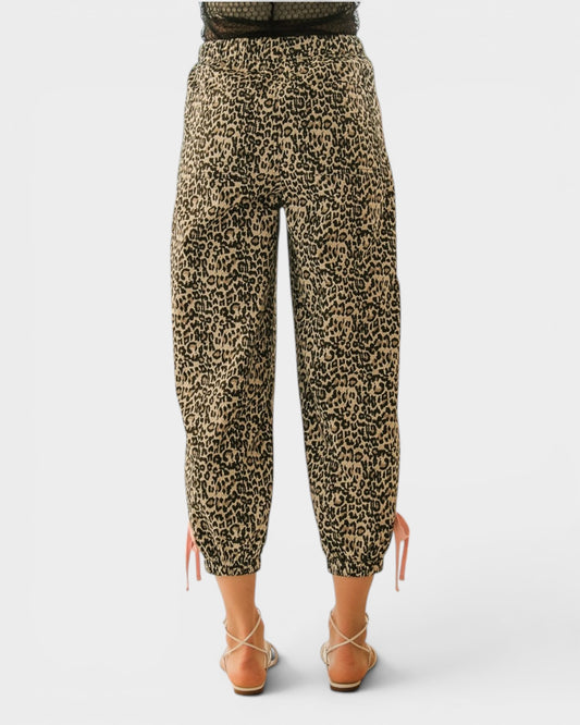 Leopard print pants worn by a person on a white background