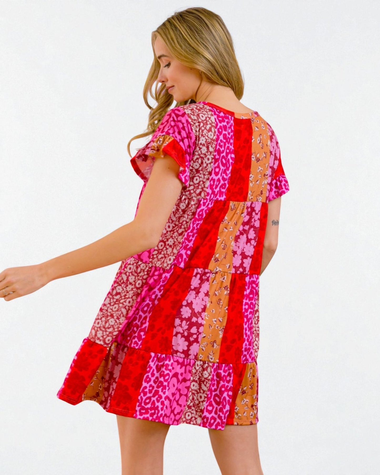 Woman wearing a colorful patchwork dress on a white background