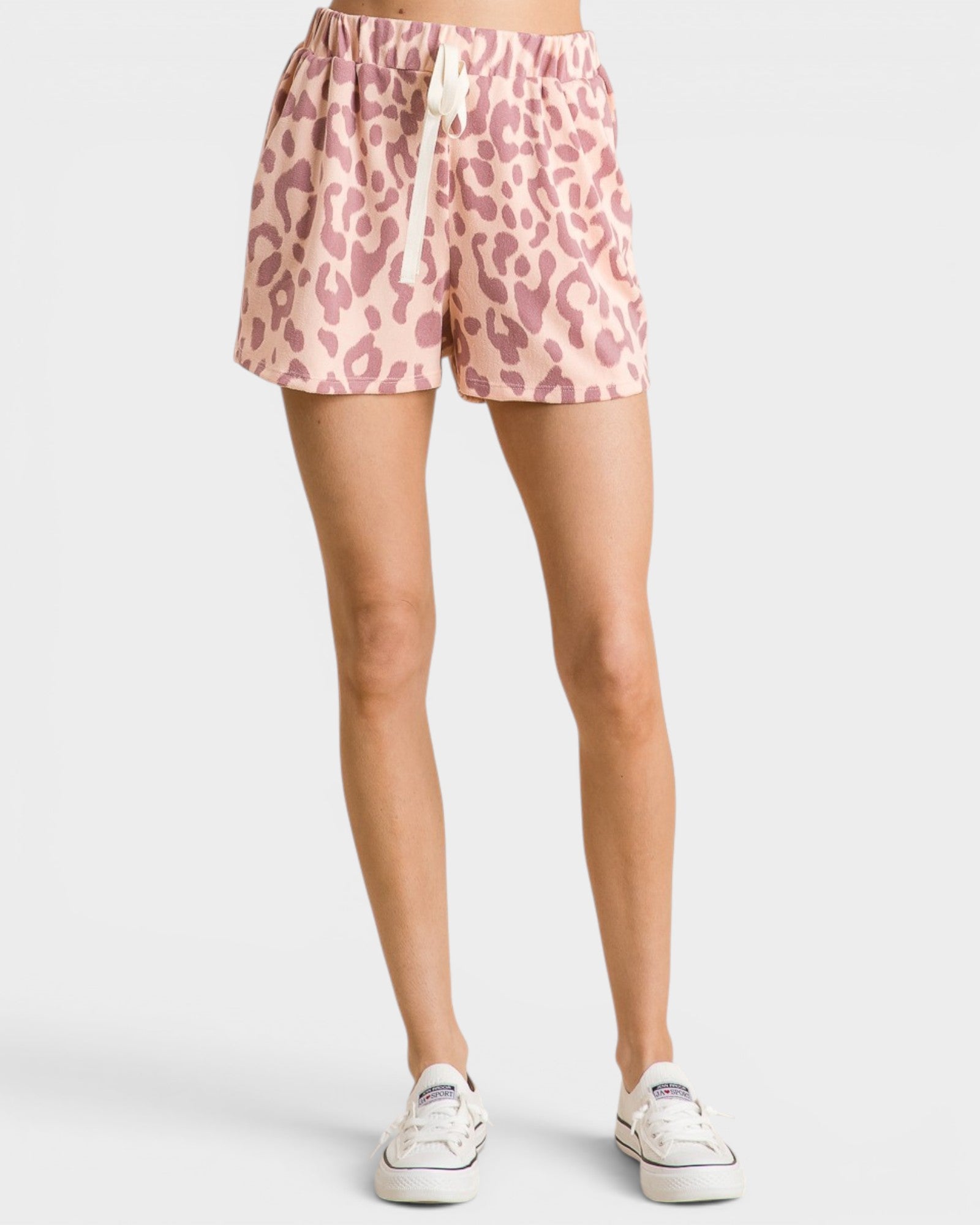 Pink leopard print shorts worn by a person on a white background