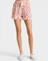 Pink leopard print shorts worn by a person on a white background