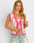 Woman wearing a colorful vest with pink accents on a plain background