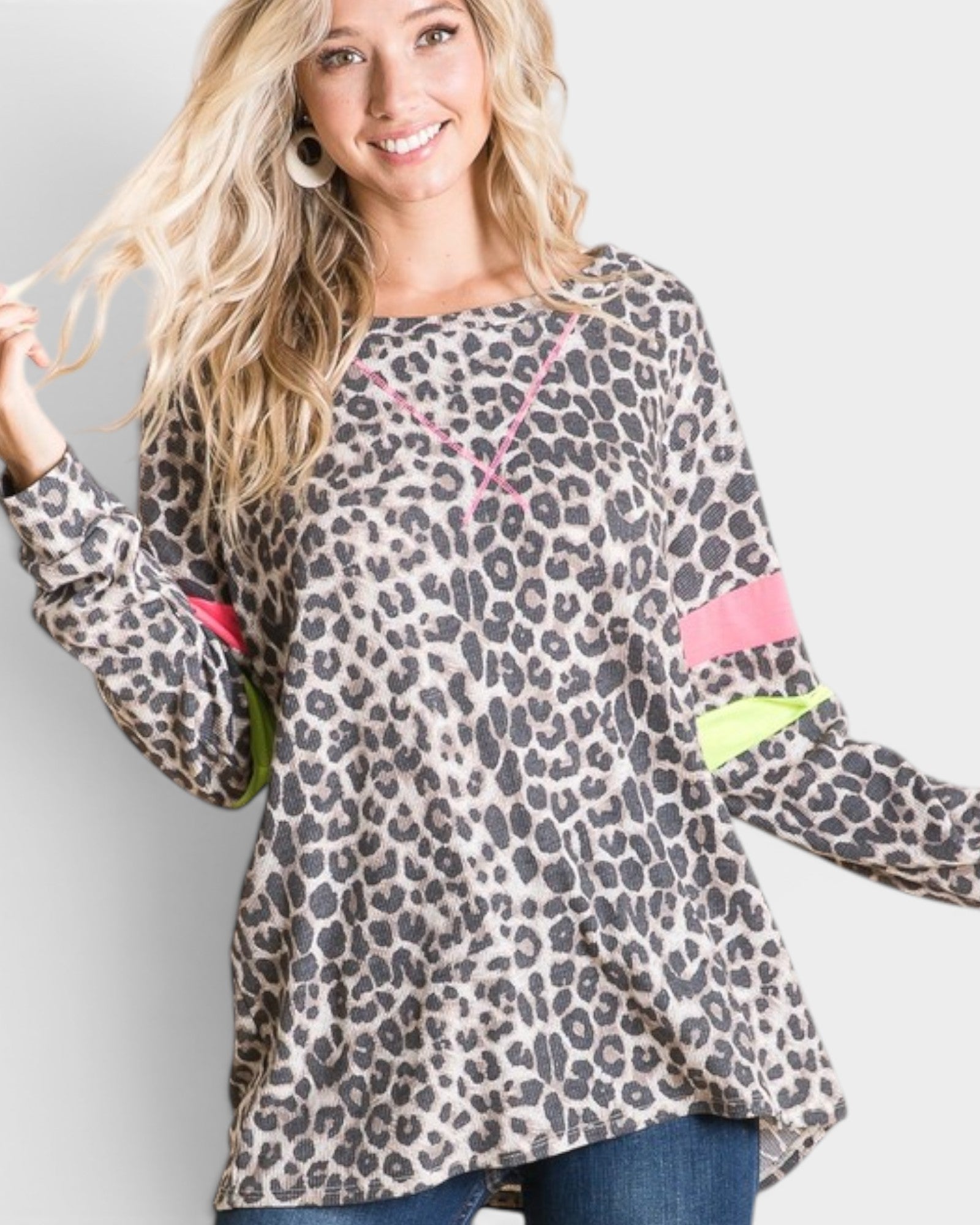Woman wearing a leopard print top with colorful accents on a plain background