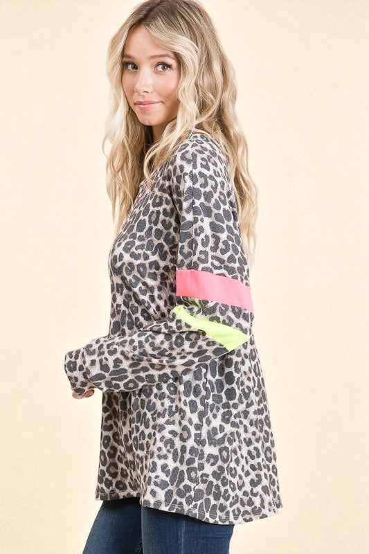 Woman wearing a leopard print jacket with colorful accents on a beige background