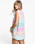 A woman modeling a sleeveless, loose-fit tunic dress with a pastel leopard print pattern in pink, mint green, and white, photographed against a clean white studio background.