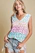 Woman wearing a pastel leopard print sleeveless top against a beige background
