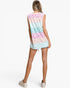 A woman shown from the back wearing a sleeveless tunic dress with horizontal pastel stripes in pink, mint green, and peach, paired with white platform sneakers against a plain white studio background.