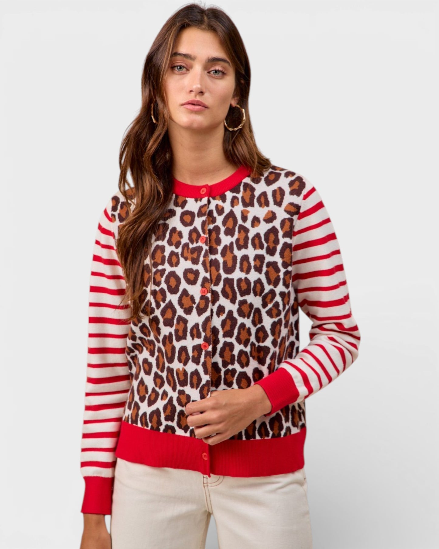 Woman wearing a leopard print and red striped sweater on a white background