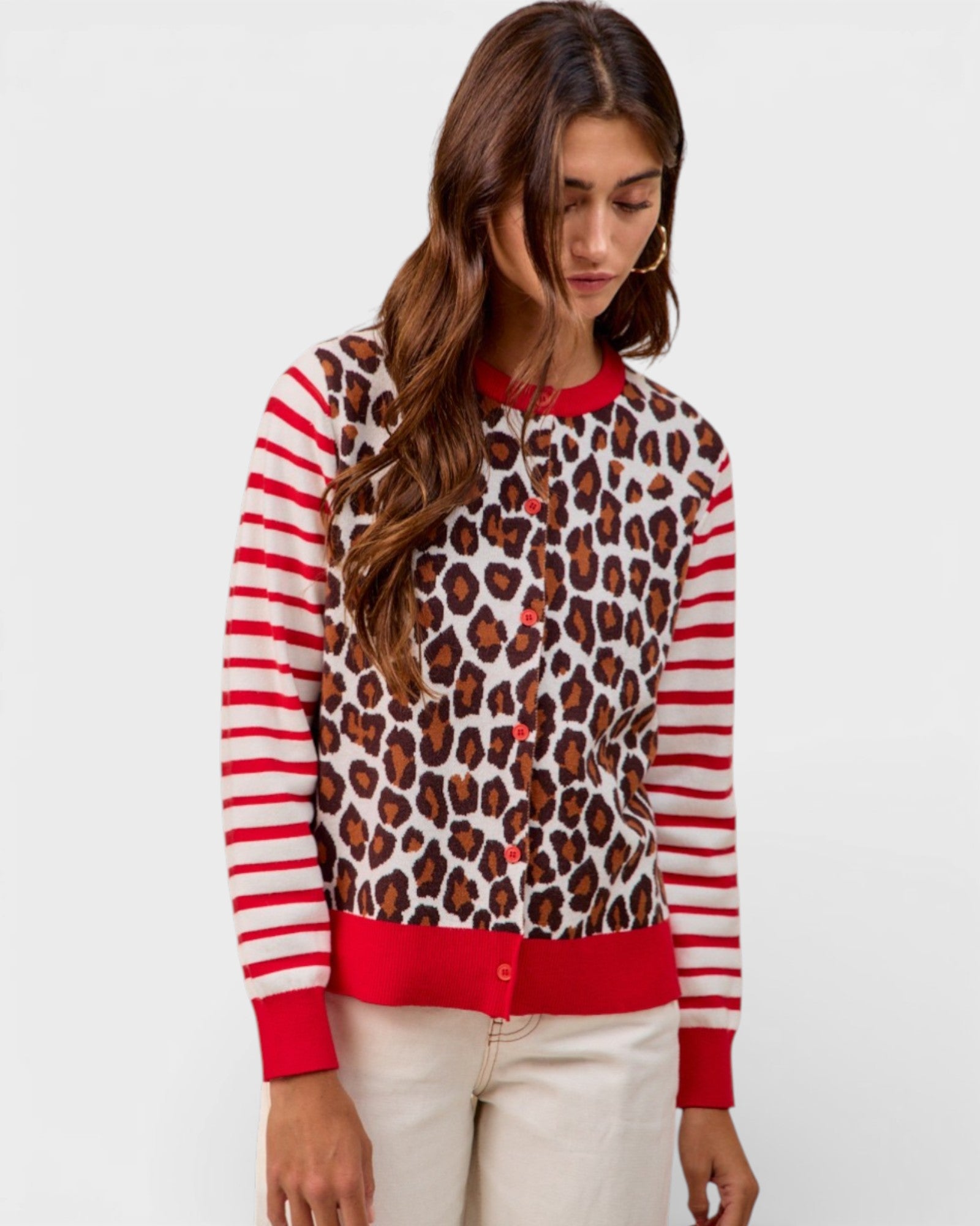 Woman wearing a sweater with leopard print and red stripes on a white background
