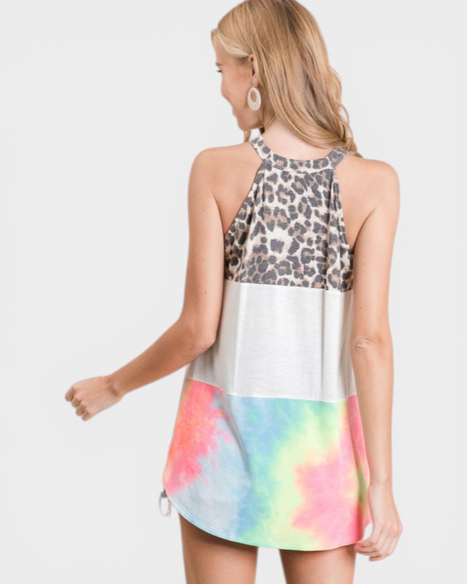 Woman wearing a dress with leopard print top and tie-dye skirt on a white background