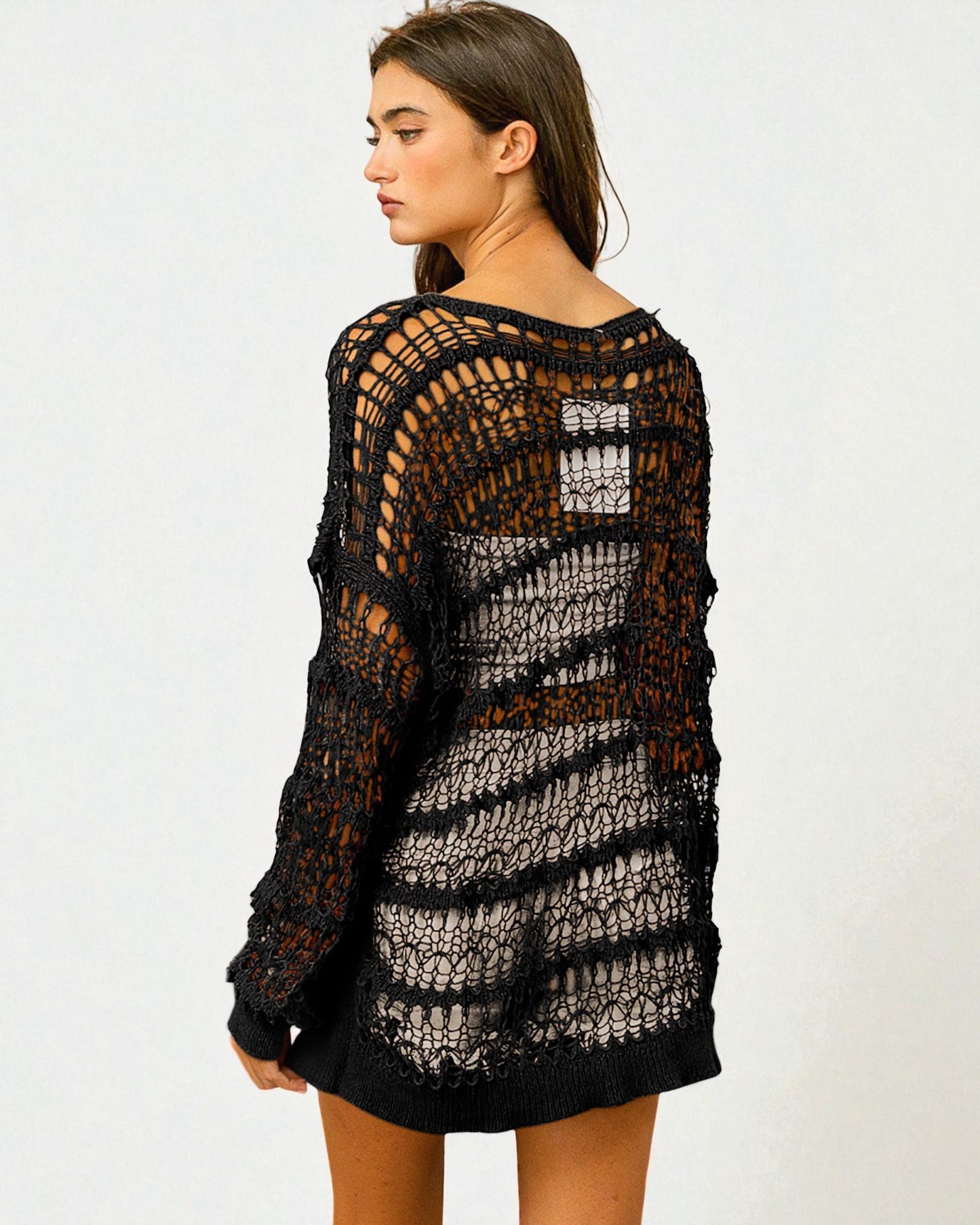 Woman wearing a black crochet dress on a white background