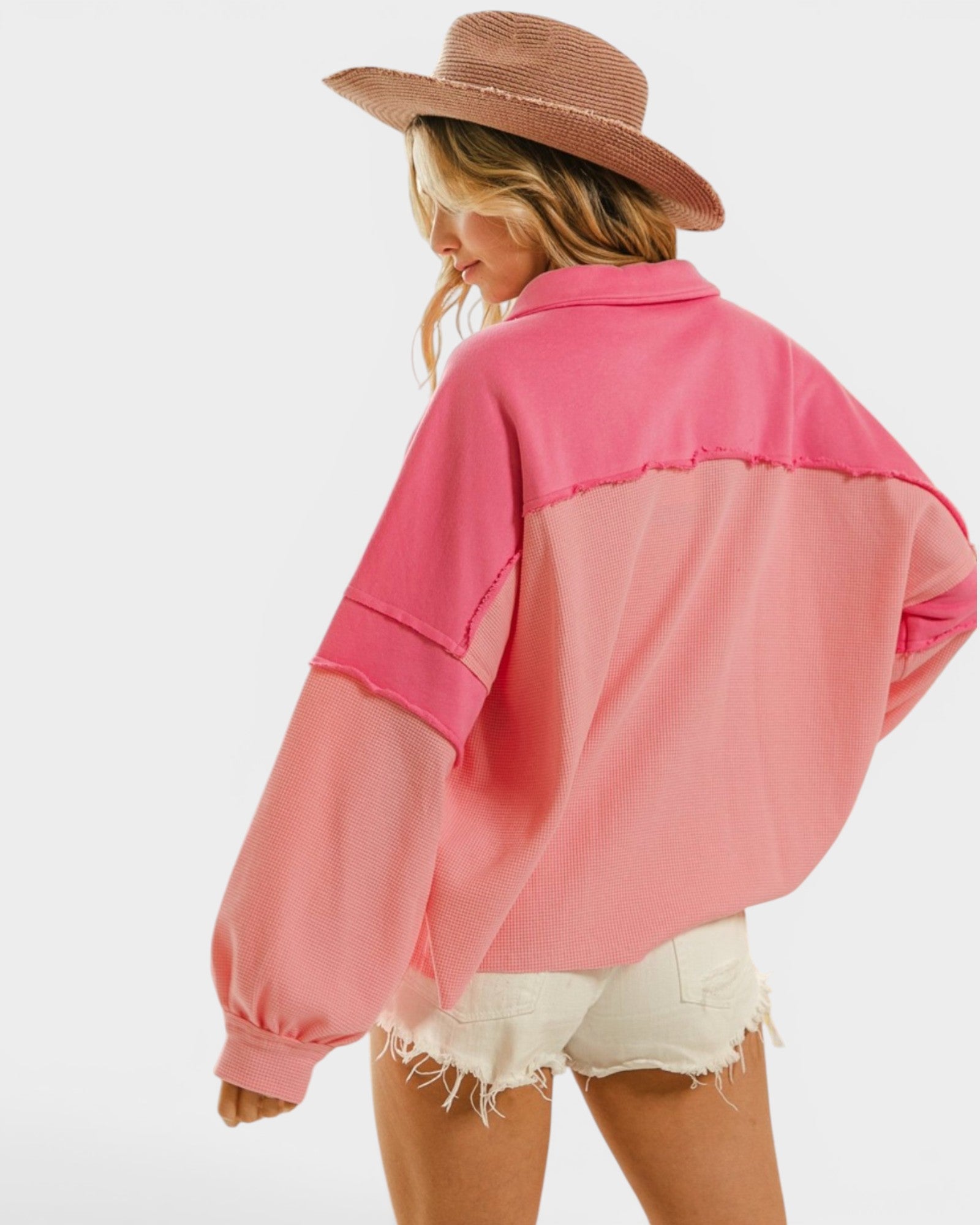 Person wearing a pink color-blocked shirt with a white background
