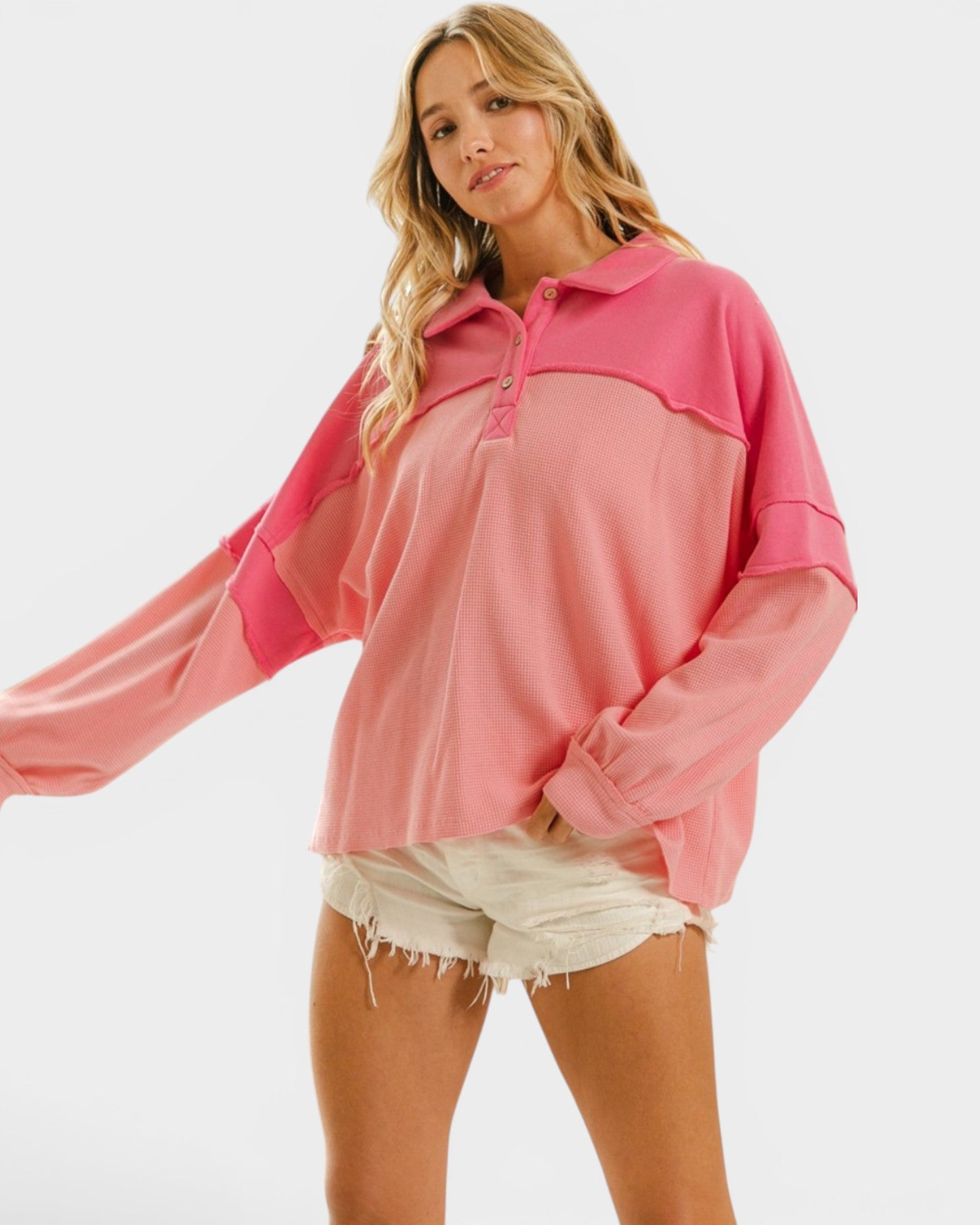 Woman wearing a pink color-blocked long-sleeve top on a white background