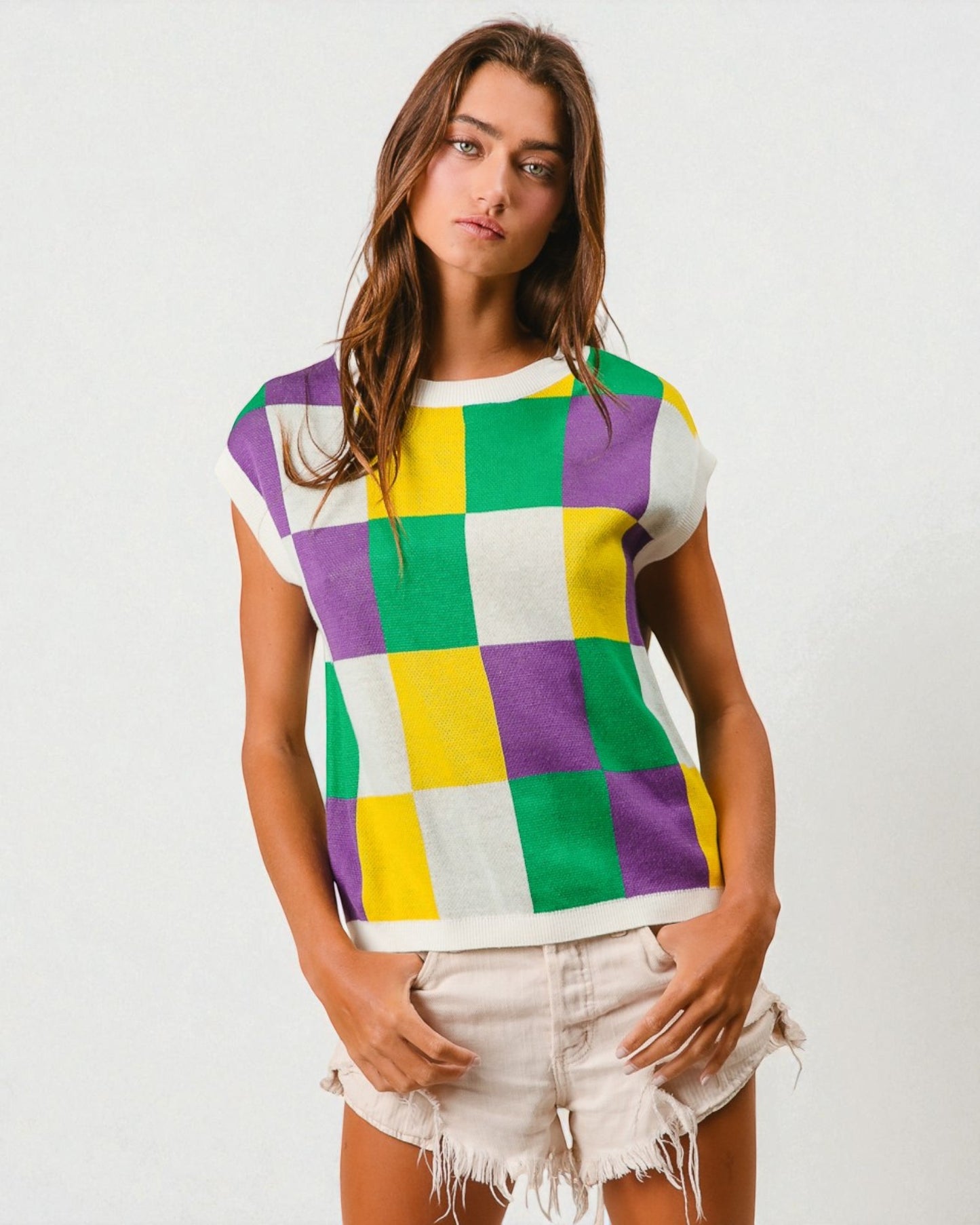 Woman wearing a colorful checkered shirt with a plain background