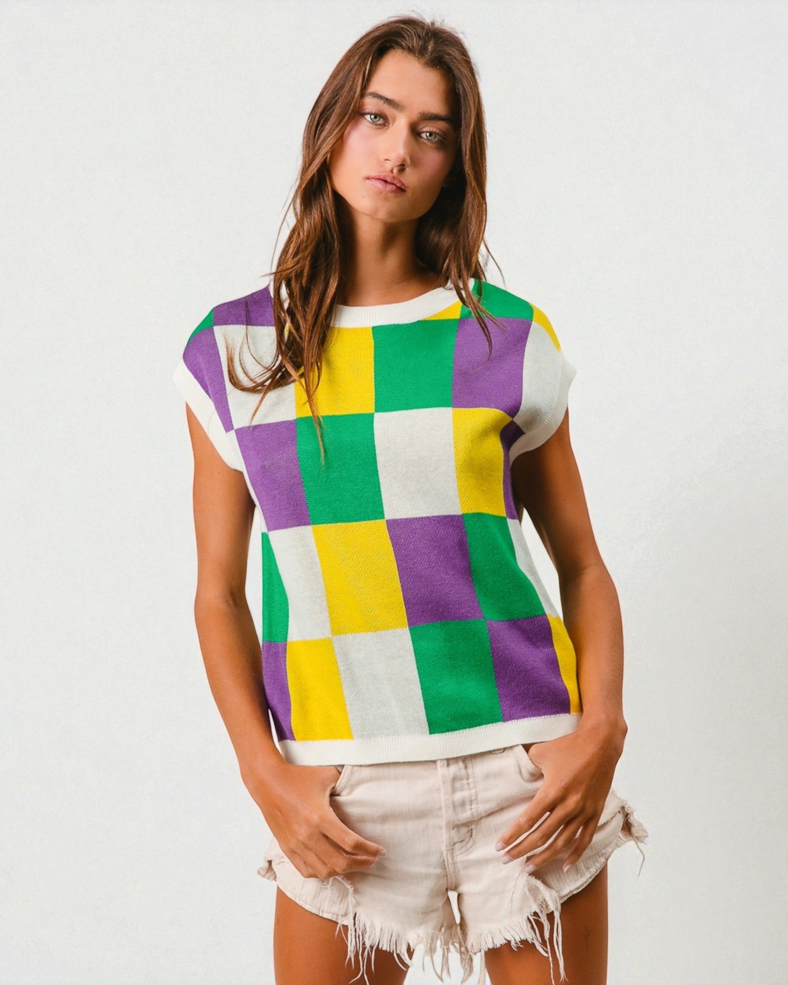 Woman wearing a colorful checkered shirt with a plain background