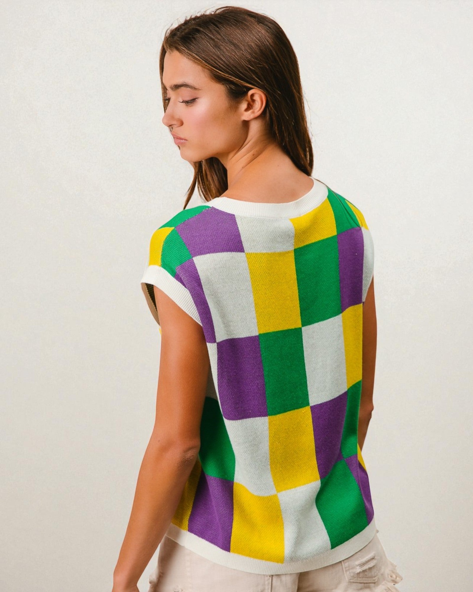 Woman wearing a colorful checkered shirt against a plain background