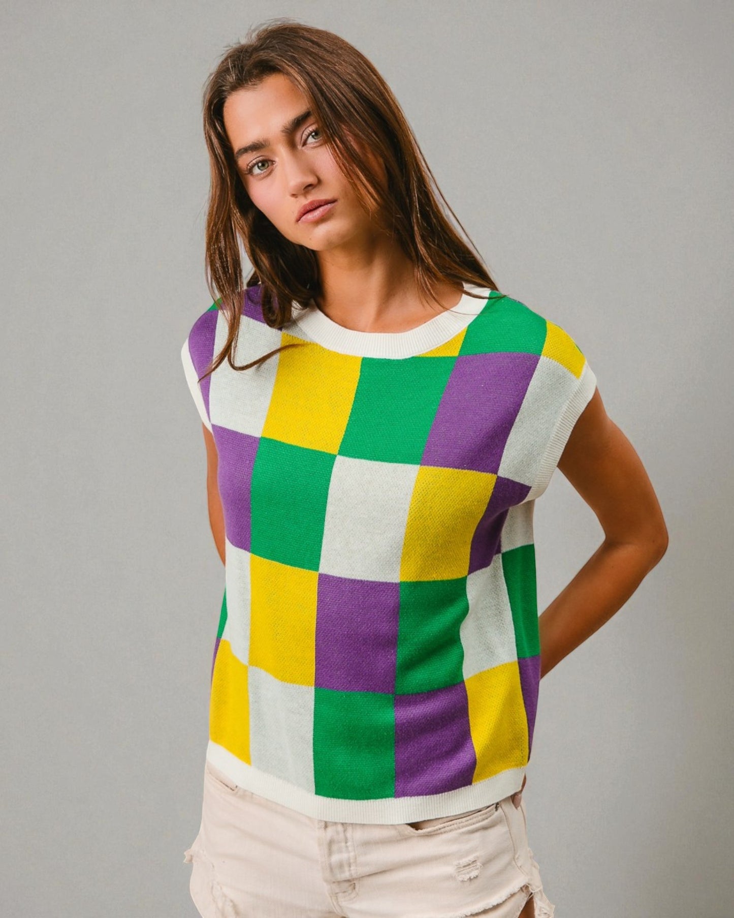 Person wearing a colorful checkered shirt against a gray background