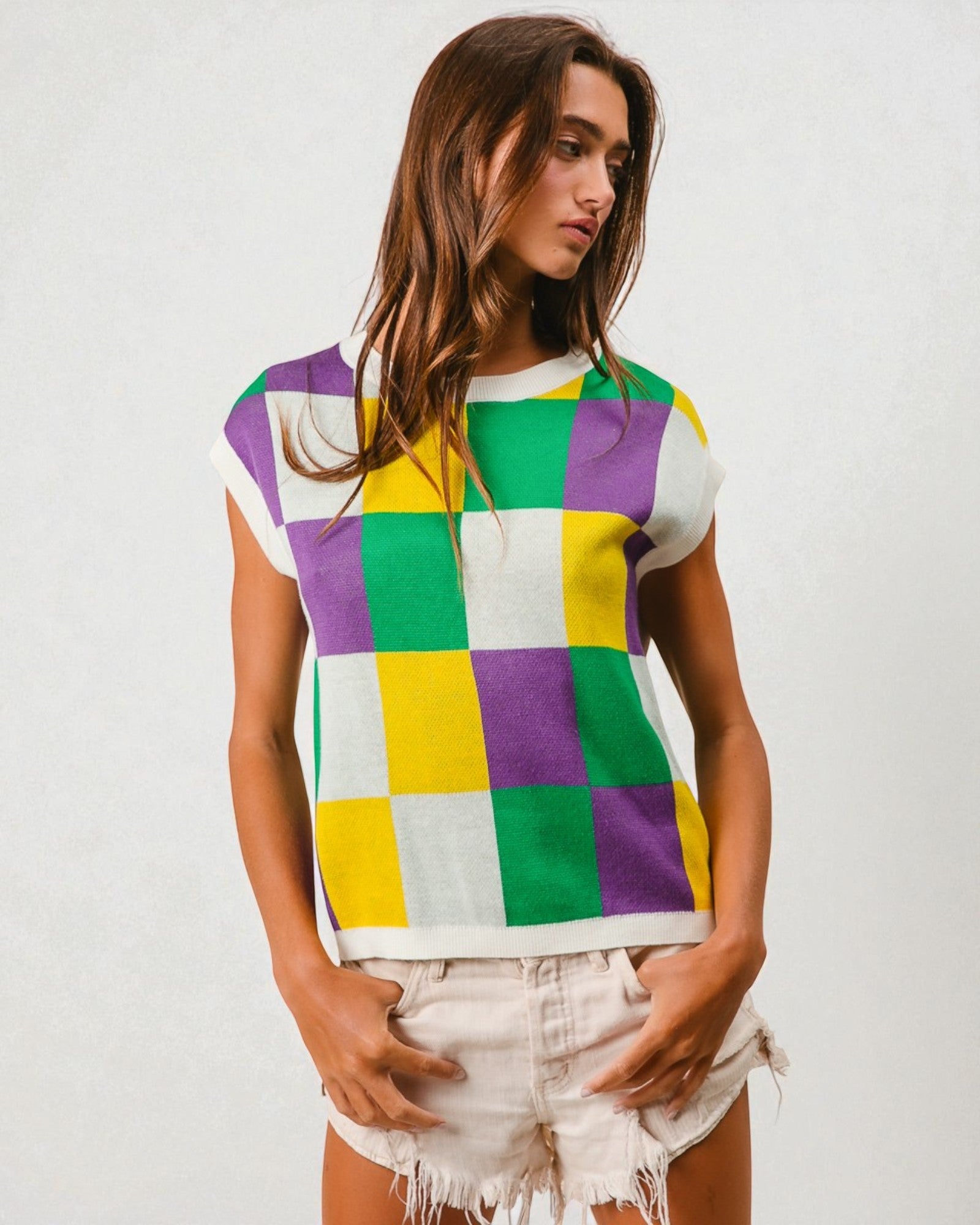 Woman wearing a colorful checkered shirt against a plain background