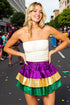 Woman in a colorful skirt with a city street background
