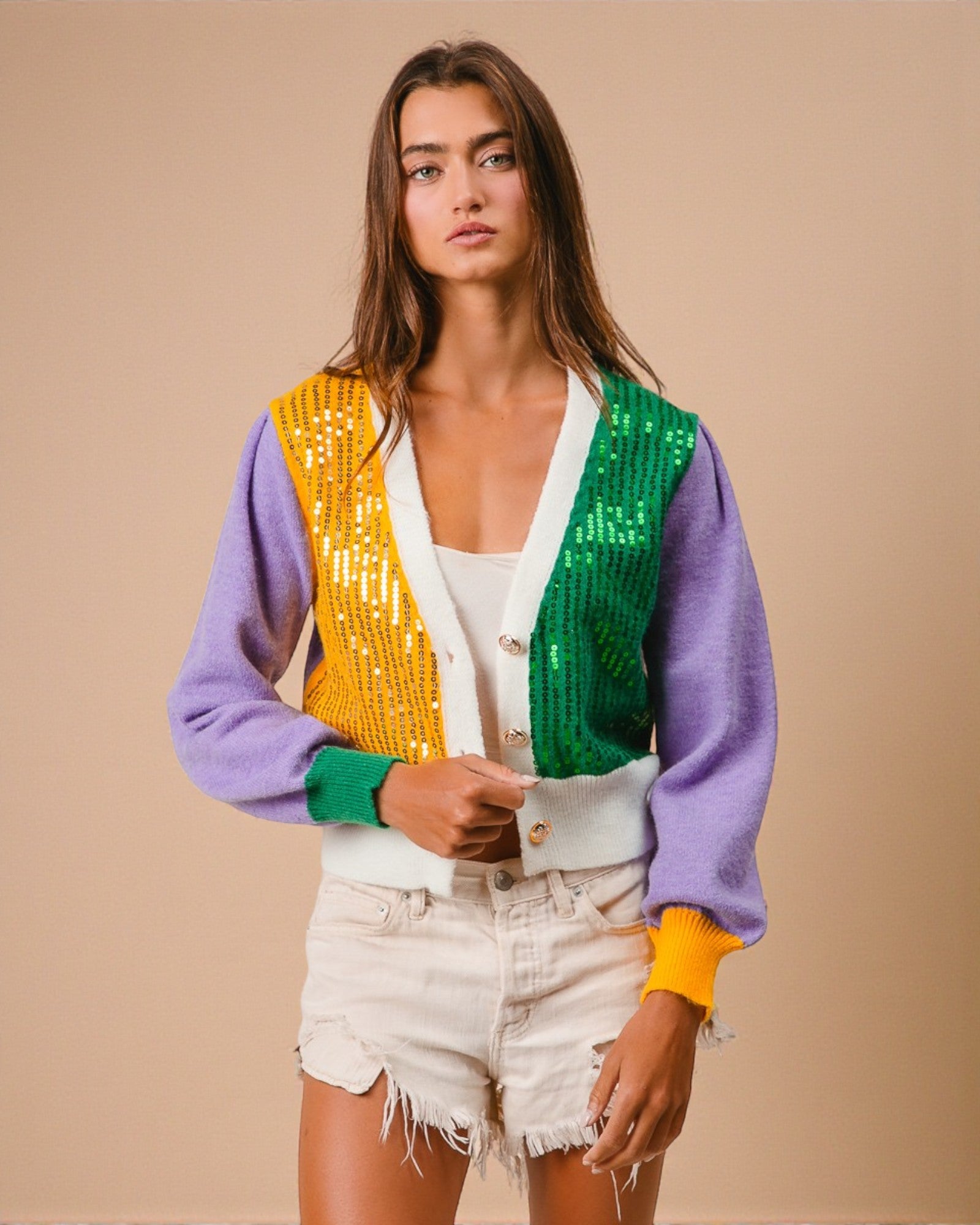 Woman wearing a colorful cardigan with a beige background