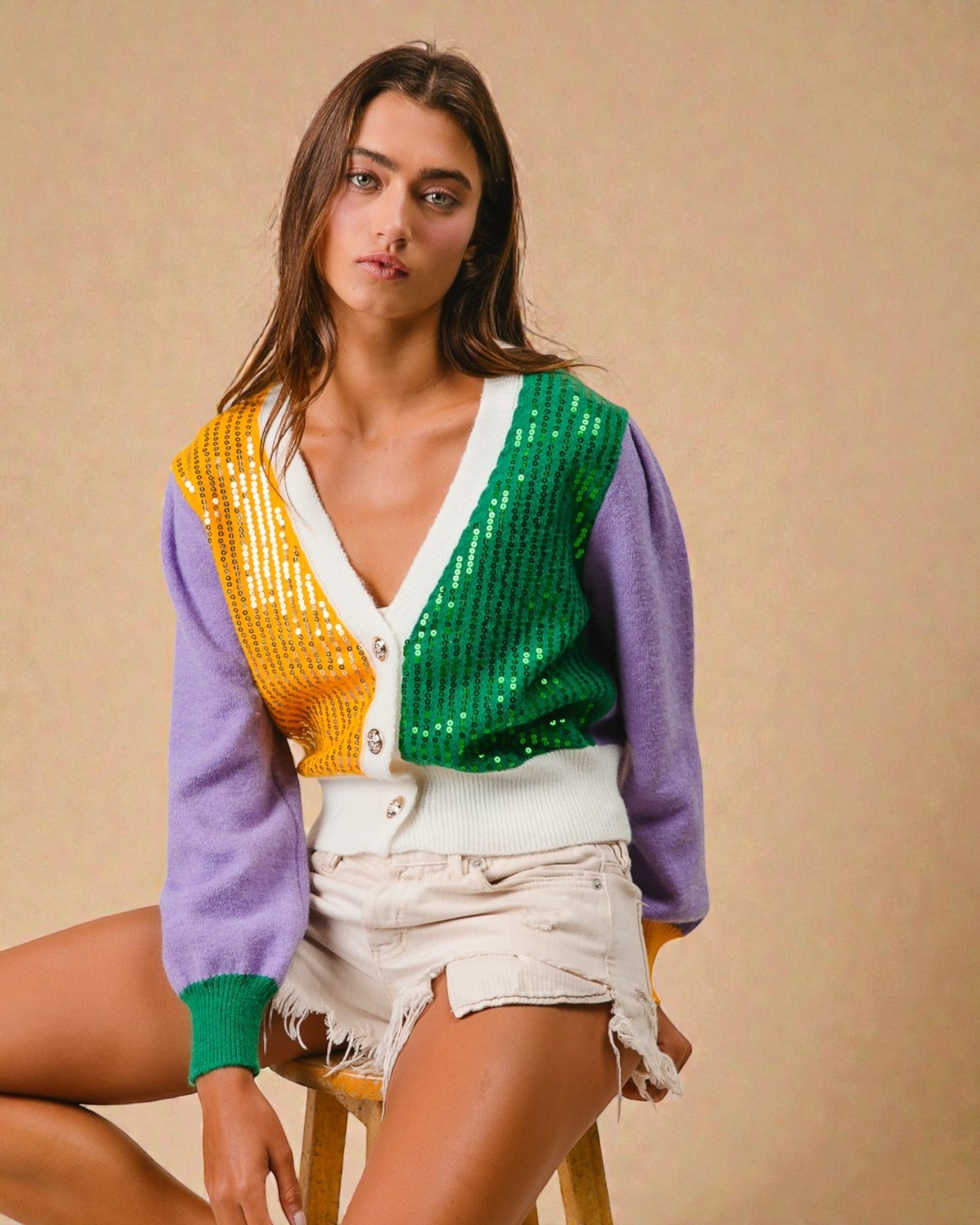 Woman wearing a colorful cardigan with a neutral background