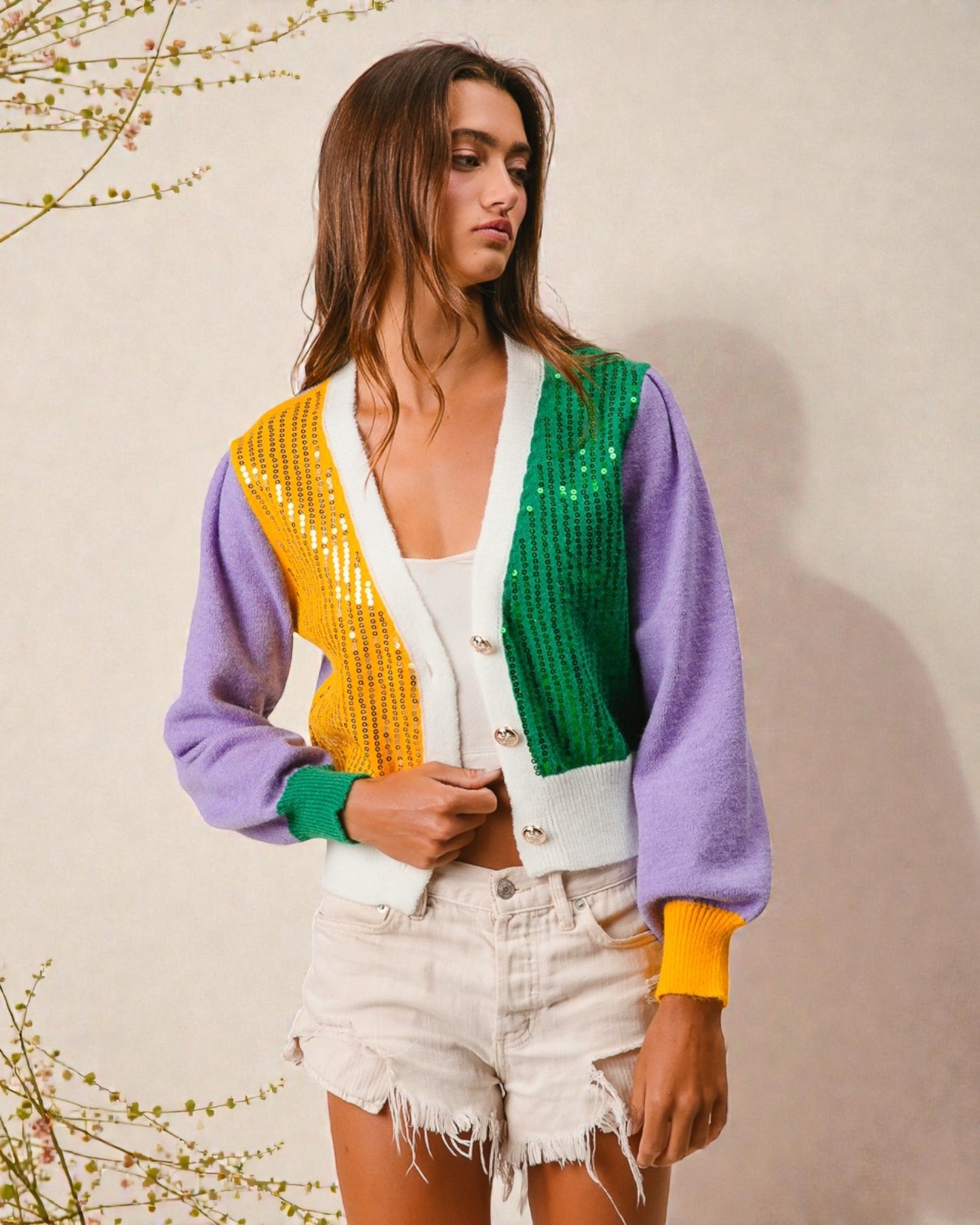 Woman wearing a colorful cardigan with a plain background