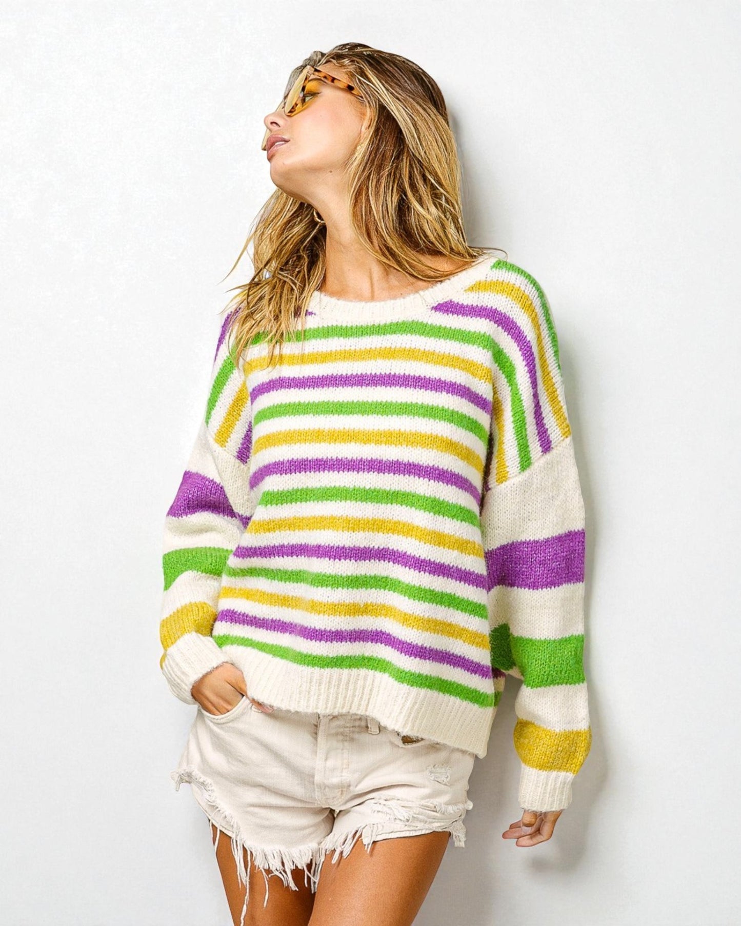 Person wearing a colorful striped sweater against a white background