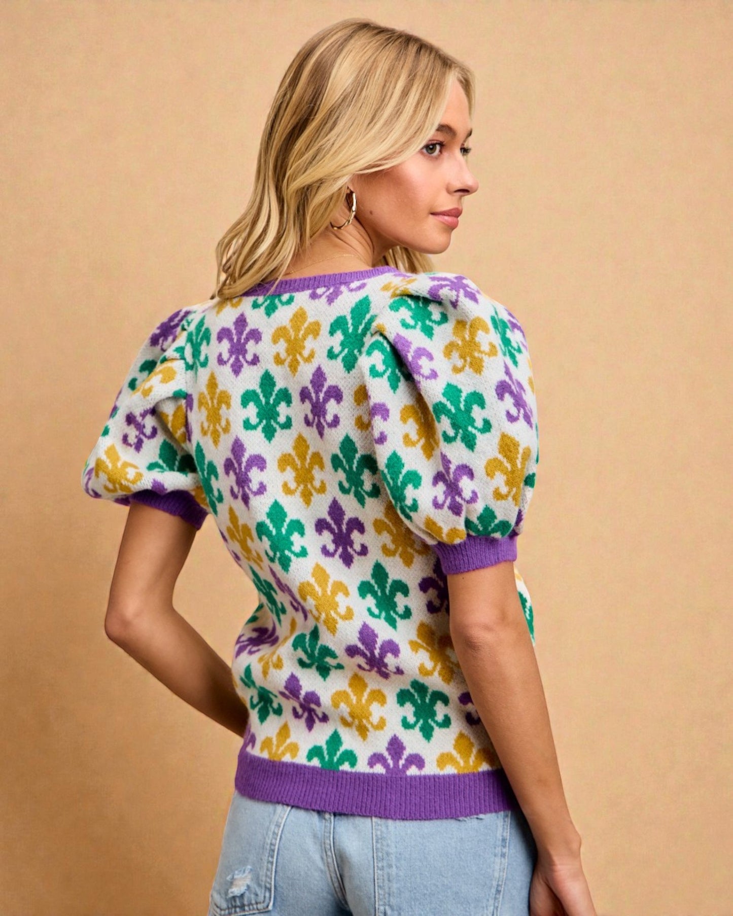 Woman wearing a colorful patterned sweater against a beige background