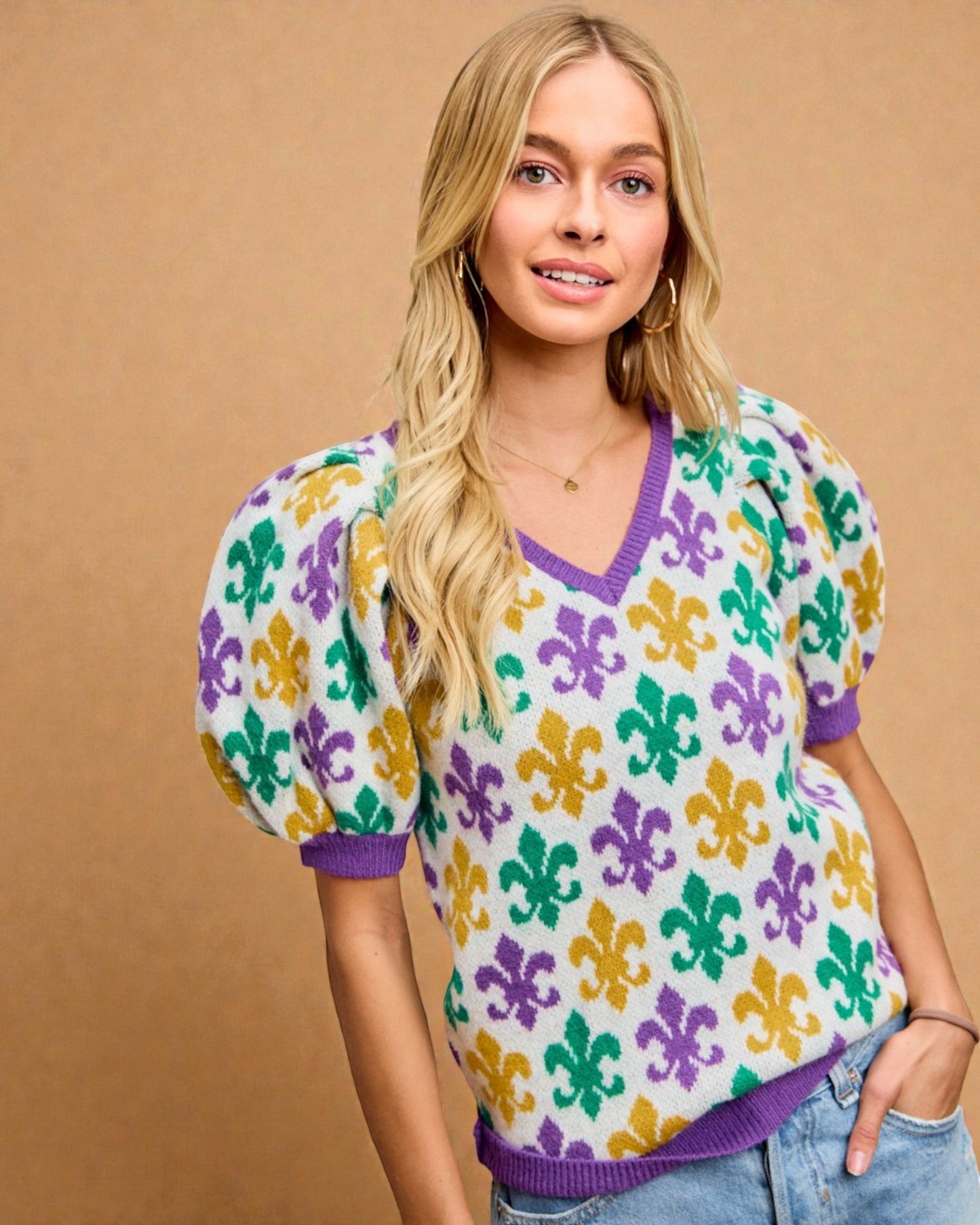 Woman wearing a colorful patterned sweater against a beige background