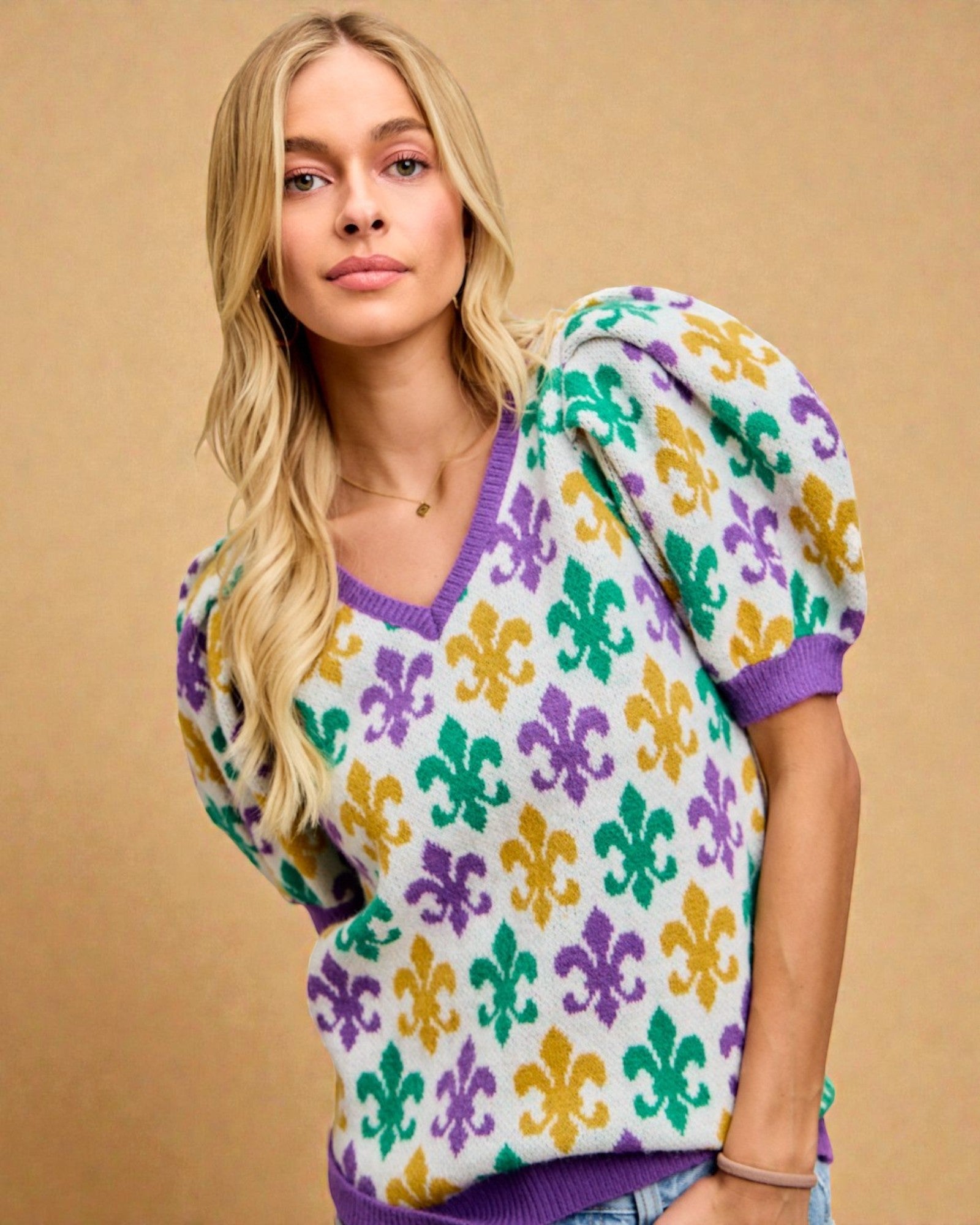 Woman wearing a colorful patterned sweater against a beige background