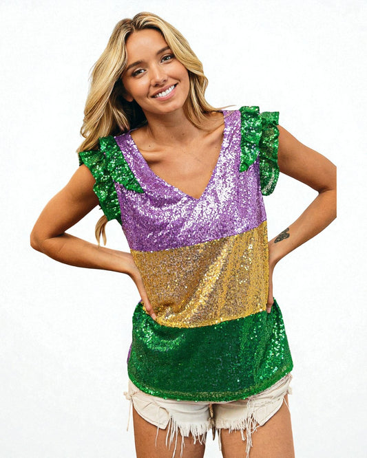 Woman wearing a colorful sequin top with green, purple, and gold on a white background