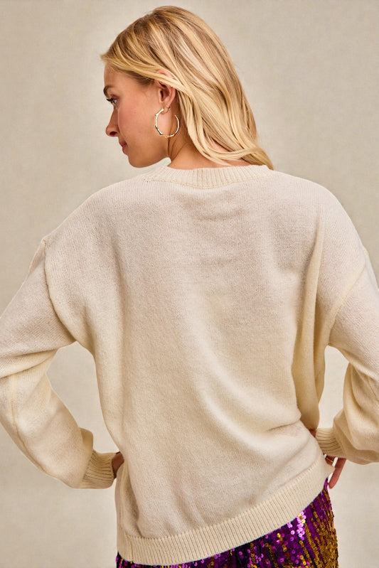 Woman wearing a beige sweater with a neutral background