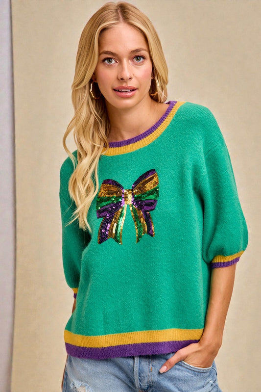 Woman wearing a green sweater with a colorful butterfly design on a beige background