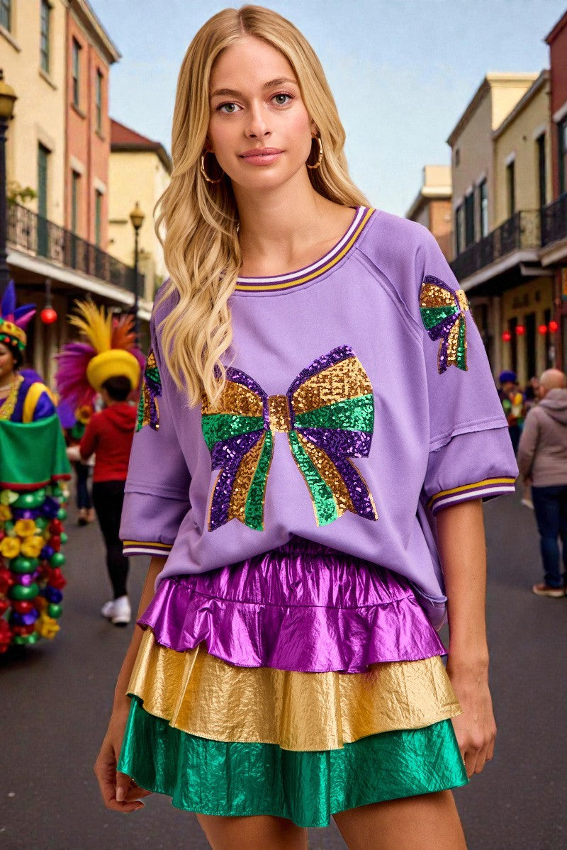 Woman wearing a colorful outfit with a large bow on a street scene