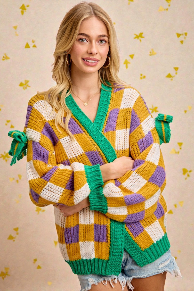 Woman wearing a colorful, patterned sweater with green accents on a beige background.