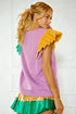 Woman wearing a colorful outfit with a purple top, yellow sleeves, and green skirt against a white background.