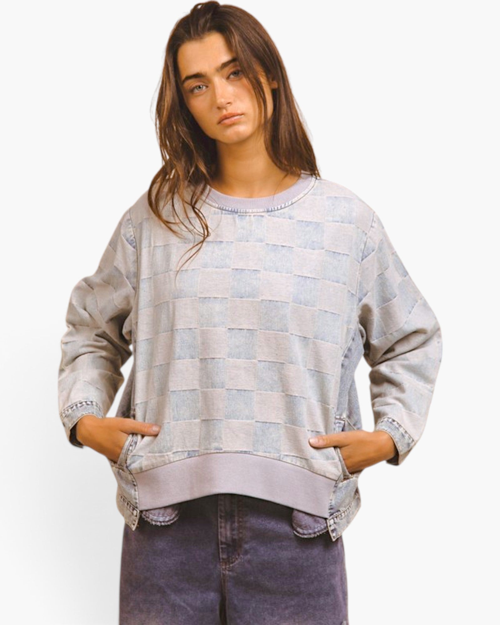 A model wearing a light blue and white checkered sweatshirt with denim-style cuffs and hem, paired with dark denim jeans, against a plain white background.