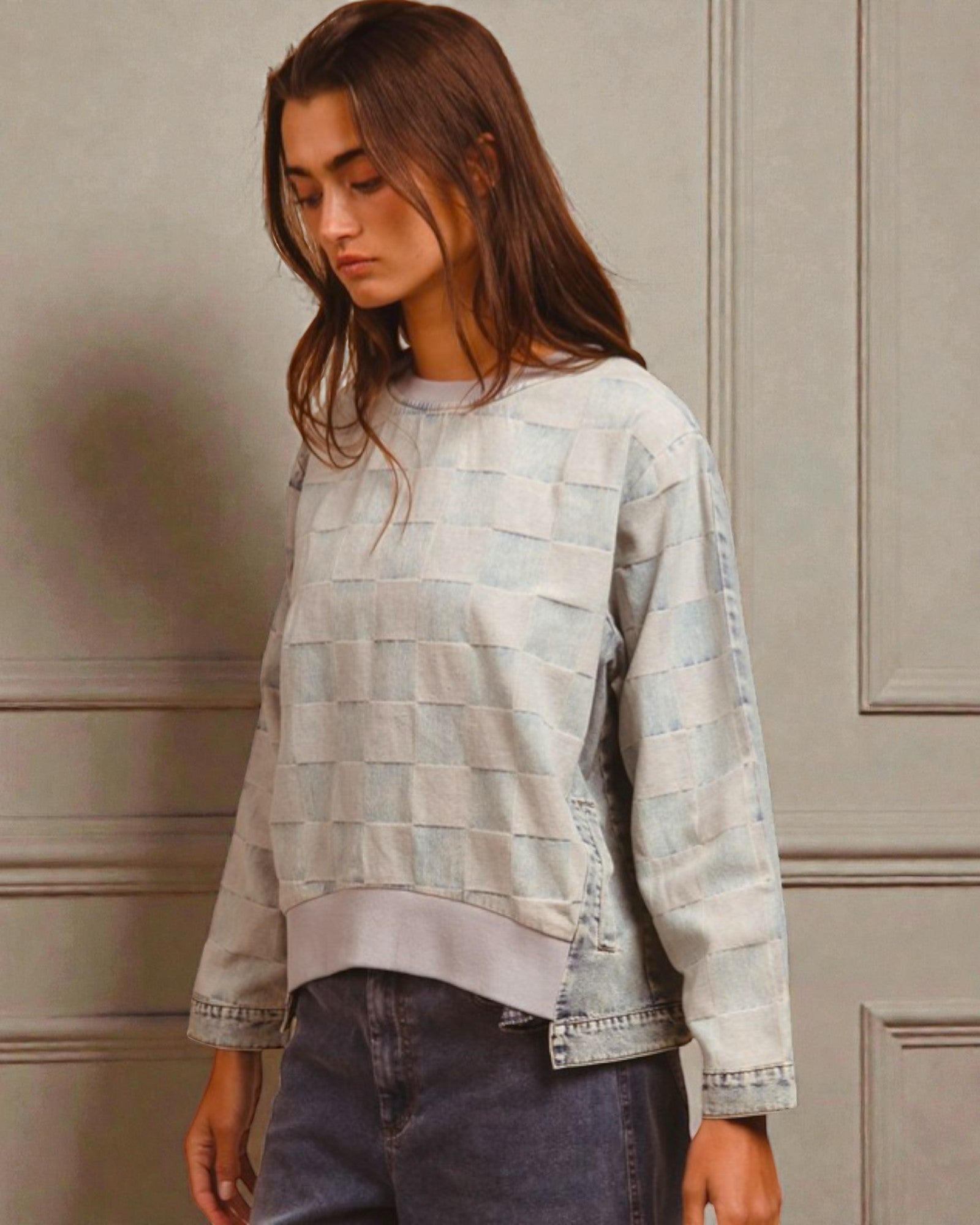 Person wearing a light blue checkered shirt against a neutral background